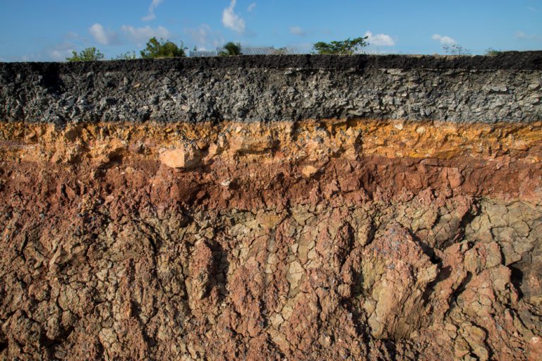 The curb erosion from storms. To indicate the layers of soil and rock.