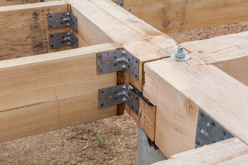 Wooden flooring base under construction. Closeup on pile foundations support the floor.