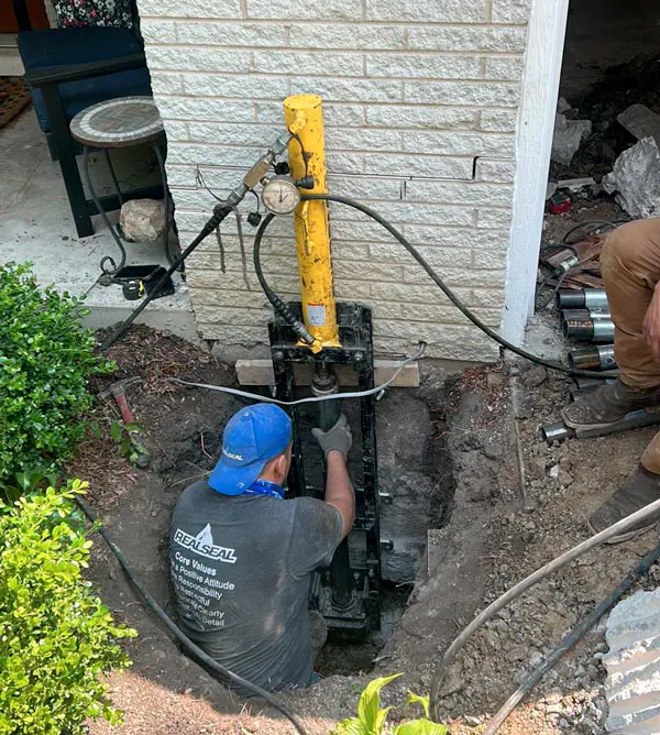 The underpinning process uses push or helical piers driven into the earth until stable soil or bedrock is reached. The piers are then attached to the foundation. As a result, the weight of the structure is resting on deep, stable soil rather than the soil at the surface.